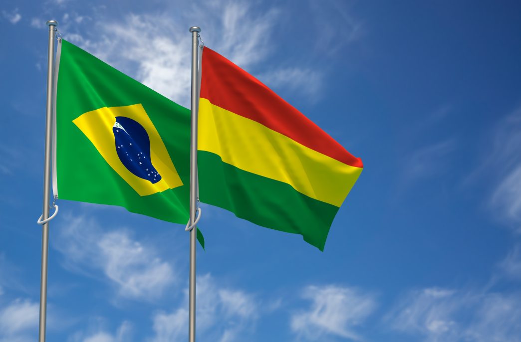 Federative Republic of Brazil and Plurinational State of Bolivia Flags Over Blue Sky Background. 3D Illustration