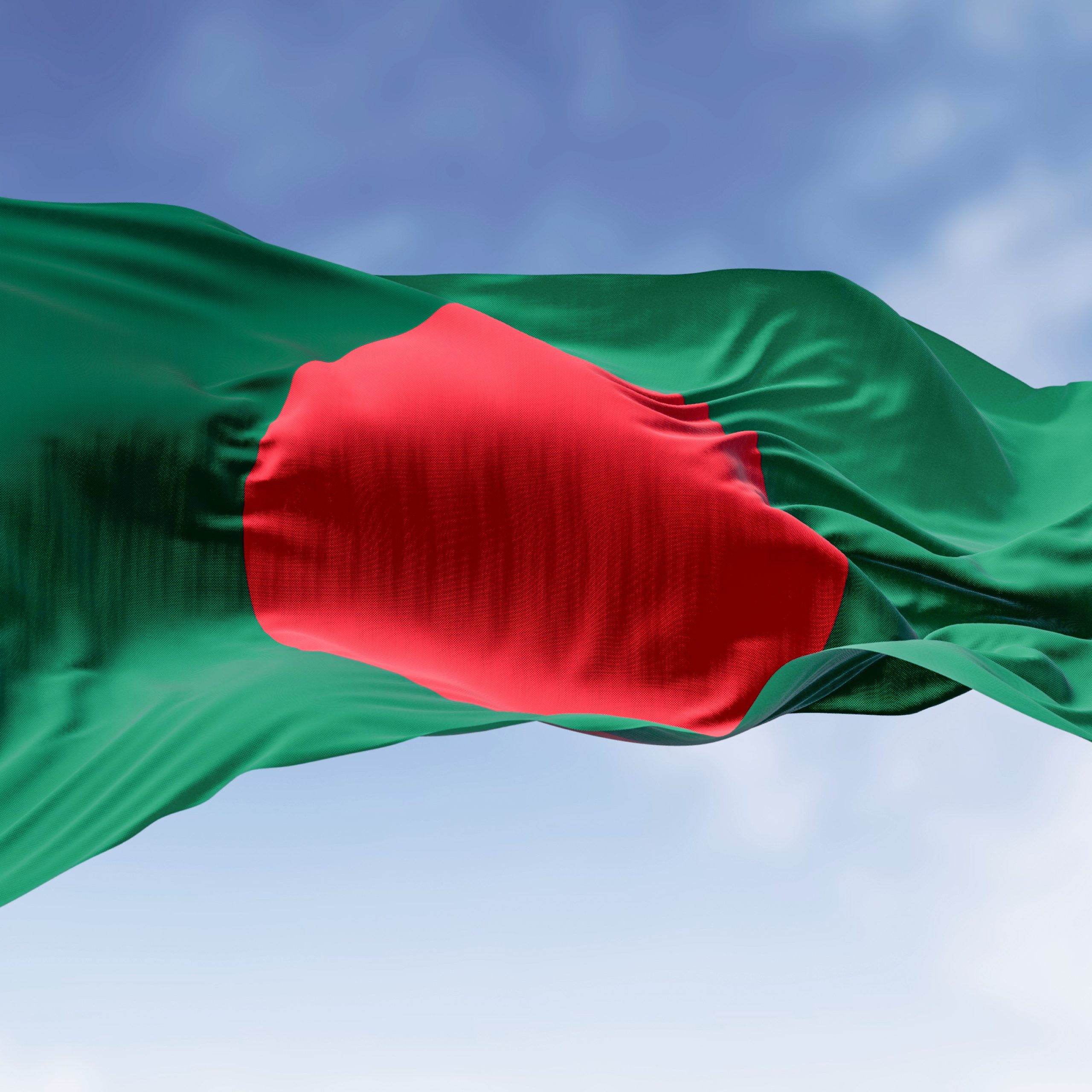 National flag of Bangladesh waving in the wind on a clear day. Dark green banner with a red disc or sun on top. 3d illustration render. Fluttering fabric