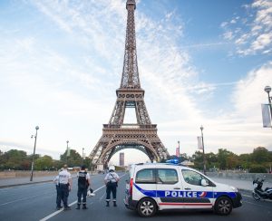 Paris, France - September 29, 2017: roadblock on eiffel tower background. Police officers and patrol transport. Police car and motorbike. Security road block. Traffic checkpoint. City on lockdown.